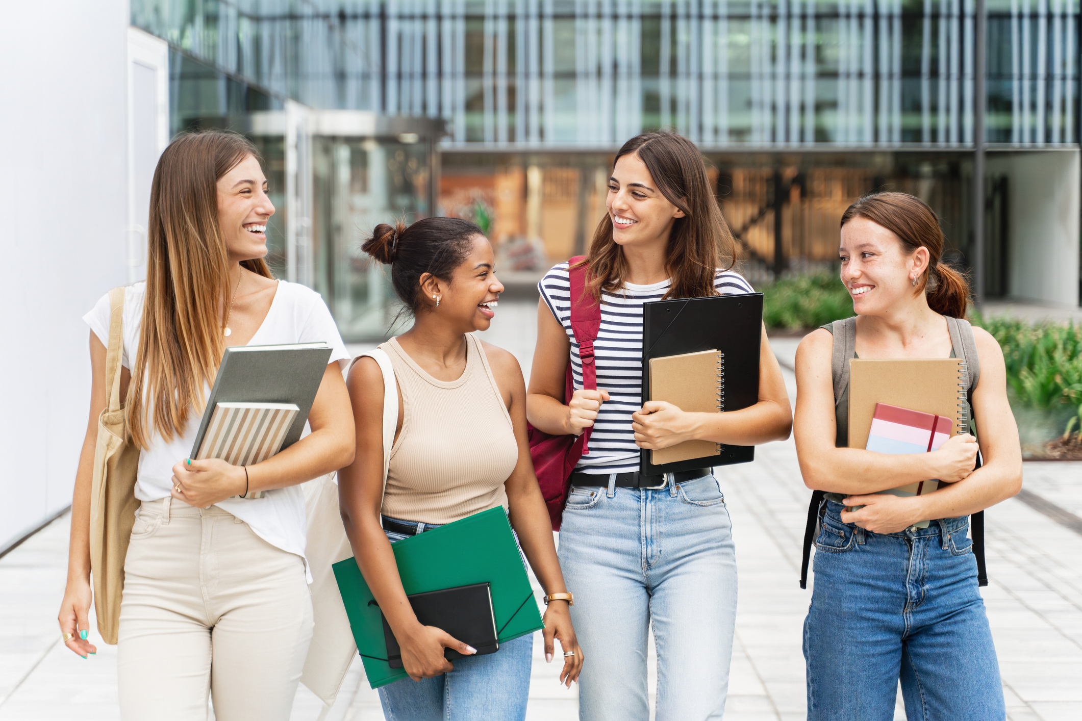 A group of college girls walking on campus, showcasing back-to-school cosmetic trends such as lip fillers, Baby Botox, and semi-permanent makeup, capturing the excitement of a fresh academic start.